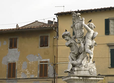 Estátua com os anjos e com o símbolo de Pisa foto